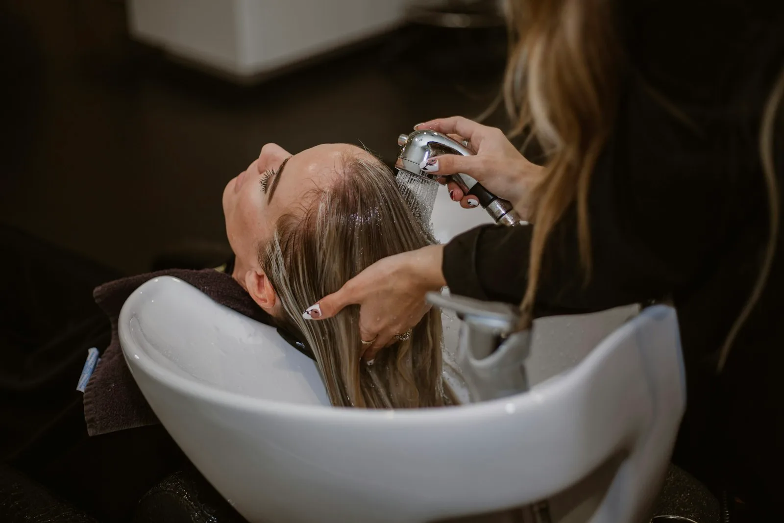 Cliente lavando o cabelo em salão de beleza